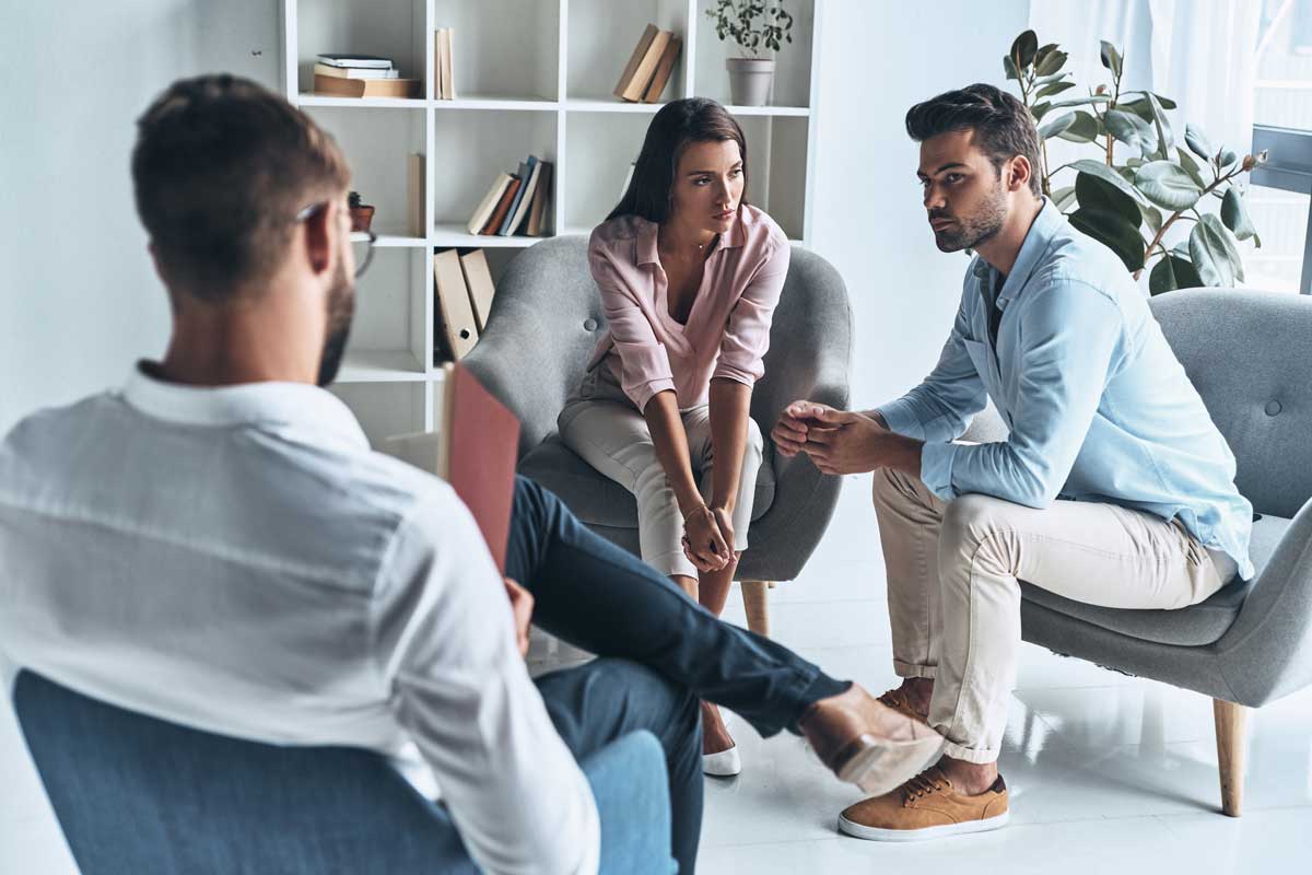 lagunashoresrecovery-How-to-Cope-with-Divorce-During-Rehab-or-Recovery--photo-of--Young-married-couple-talking-while-sitting-on-the-therapy-session-with-psychologist