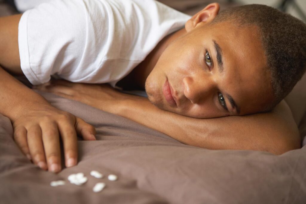 Laguna-Shores-Recovery-The Most Difficult Drugs to Kick photo-of-depressed-Teenage-Boy-Lying-In-Bedroom-With-Pills