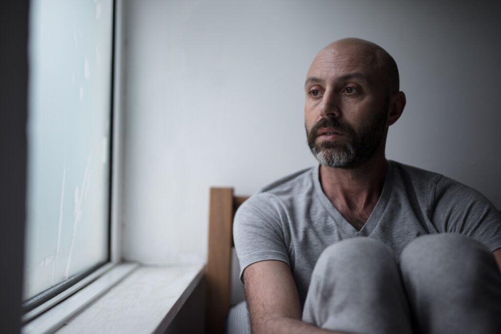 an alcoholic man staring outside the window